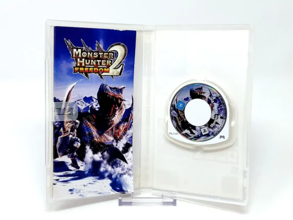 Interior del juego Monster Hunter Freedom 2 (ESP) para PSP con disco y manual