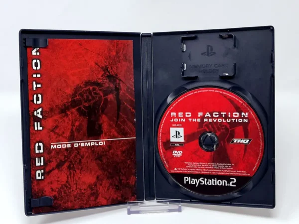 Interior del juego Red Faction (FRA) para PlayStation 2 con disco y manual