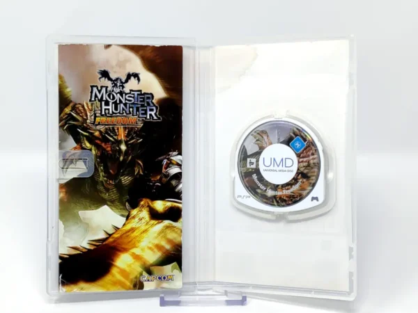 Interior del juego Monster Hunter Freedom (ESP) para PSP con disco y manual