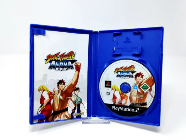 Interior del juego Street Fighter Alpha Anthology (UK) para PlayStation 2 con disco y manual
