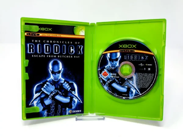 Interior del juego The Chronicles of Riddick: Escape from Butcher Bay (UK) para XBOX con disco y manual
